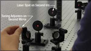 To perform a beam walk, use the adjusters on the second mirror to adjust the beam position on the second iris.